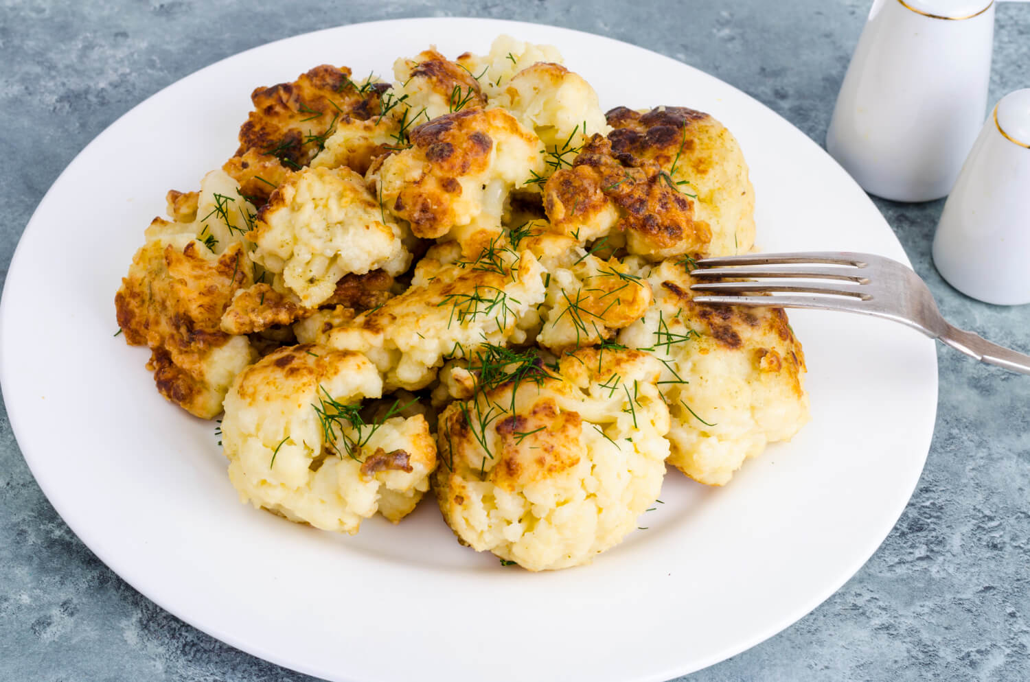 Cavolfiore in airfryer dorato su un piatto.