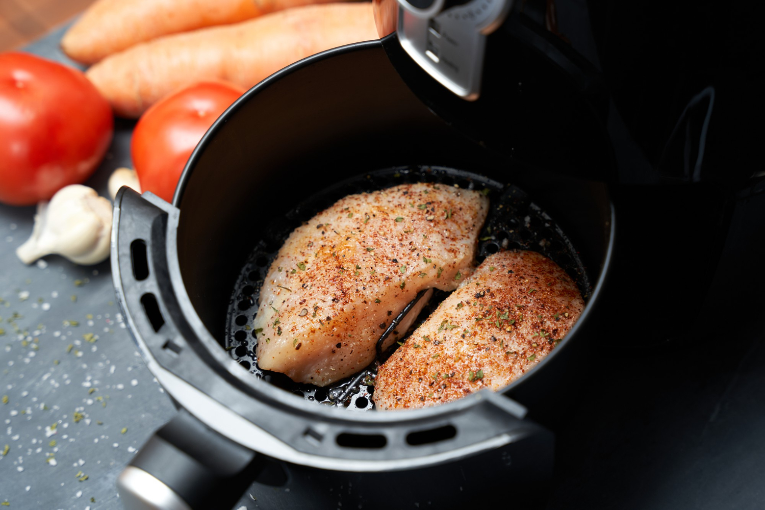 Pezzi di salmone in friggitrice ad aria croccanti e dorati.