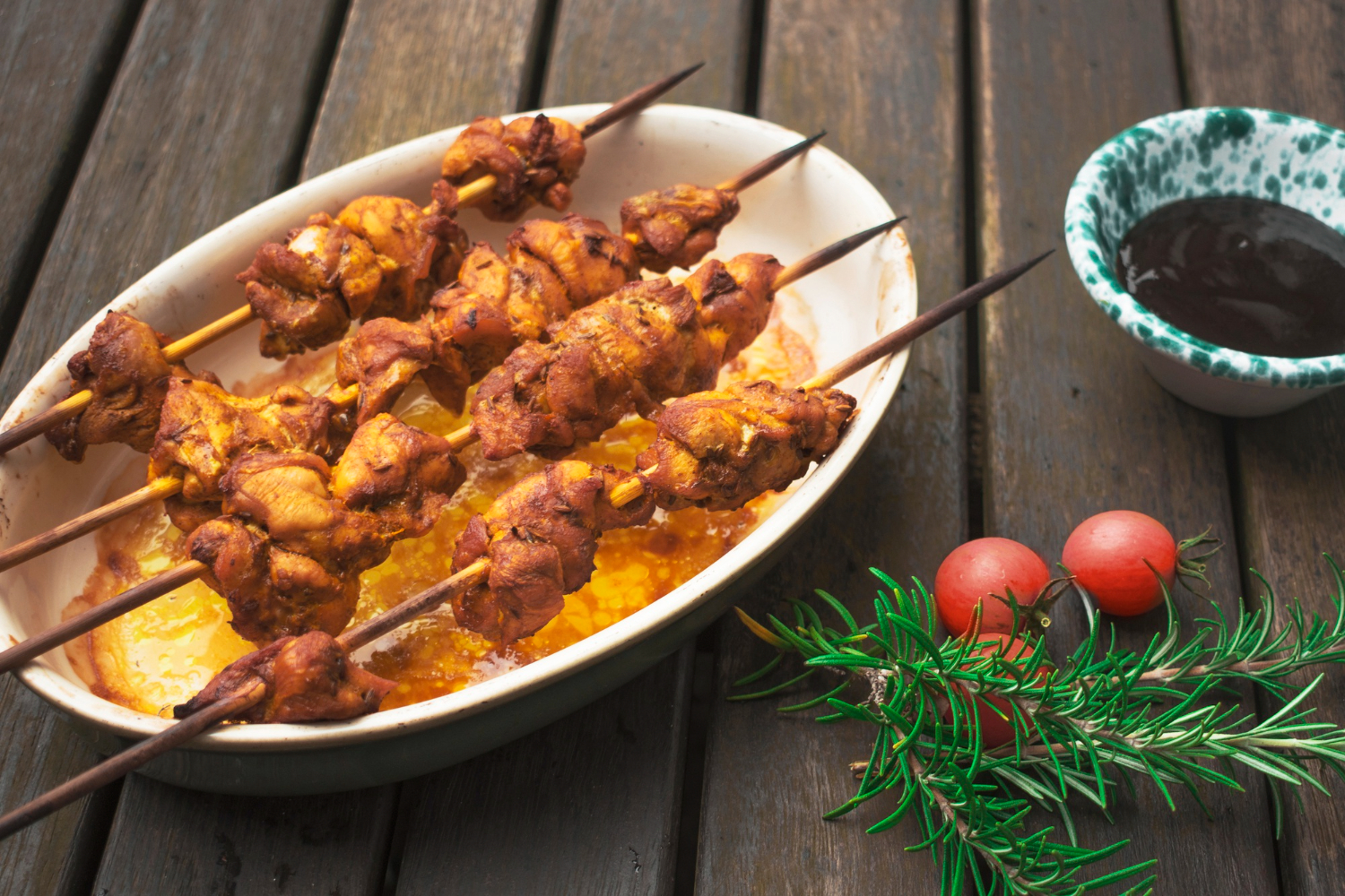 Spiedini di pollo in friggitrice ad aria dorati e croccanti nel cestello della friggitrice.