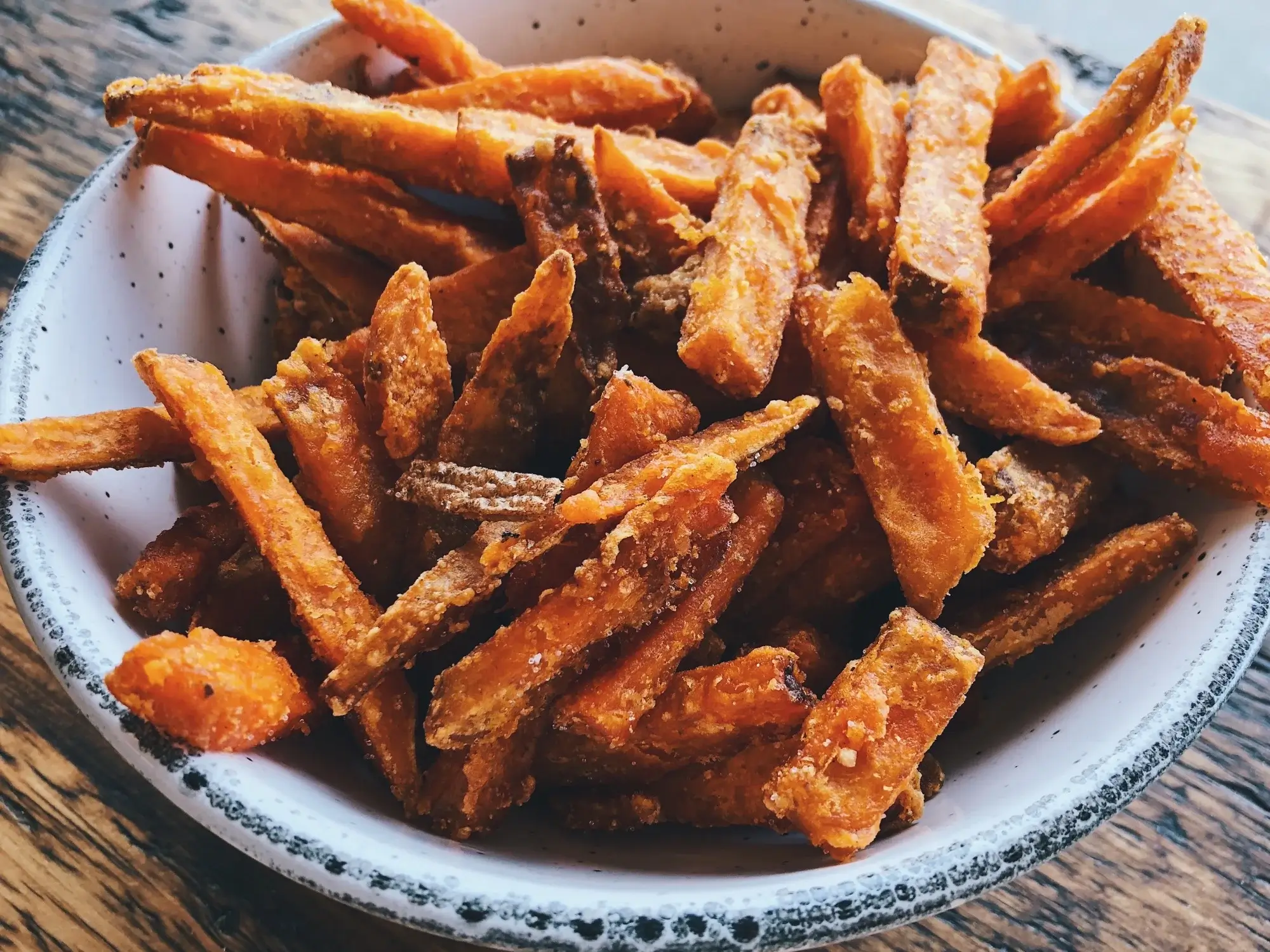 Patatine di patate dolci croccanti in airfryer servite su un piatto.